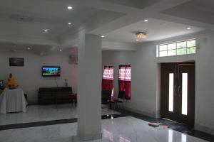 sala de estar con sofá y TV en la pared en HOTEL BODHGAYA INN, en Bodh Gaya