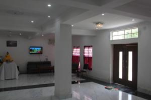 a living room with a couch and a tv on a wall at HOTEL BODHGAYA INN in Bodh Gaya