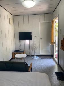 1 dormitorio con 1 cama, TV y mesa en 好貨舍 en Xiaoliuqiu