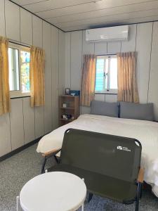 Habitación hospitalaria con cama, mesa y ventanas en 好貨舍 en Xiaoliuqiu