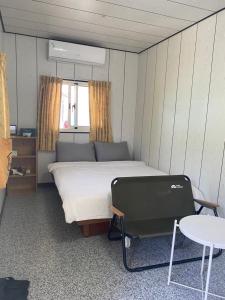 1 dormitorio con cama, mesa y mesa en 好貨舍 en Xiaoliuqiu