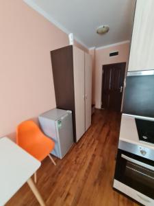 a living room with an orange chair and a television at MitProt Panorama Bay 2 ap 31 in Sveti Vlas