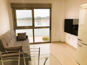a living room with a couch and a large window at El capricho de la Ría I in O Grove
