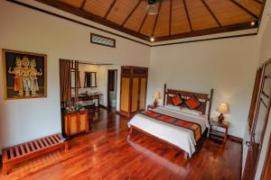 a bedroom with a bed and a wooden floor at Le Grand Pakbeng in Pakbeng