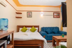 a bedroom with a bed and a blue couch at Shalom Apartments in Naivasha