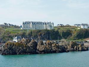 um grande castelo no topo de uma colina junto à água em Seaviews And Hot Tub At Admirals Anchor em Portpatrick