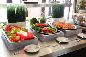 un buffet con varias bandejas de diferentes tipos de verduras en Wittenbeck Resort, en Kühlungsborn