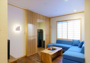 a living room with a blue couch and a table at YADOYA 雀 in Tokyo