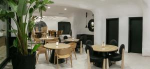 a restaurant with wooden tables and chairs and plants at Elisabeth Boutique Hotel in Thessaloniki