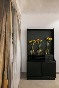 Elisabeth Boutique Hotel في سلانيك: خزانة سوداء مع مزهريات مع الزهور عليها