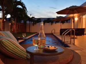 una botella de vino y un bol de fruta en una mesa en Pool Villa Imadomari by Coldio Premium en Nakijin