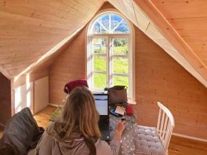 a woman sitting at a desk in a attic at 4 person holiday home in MÅLØY-By Traum in Måløy +12 photos