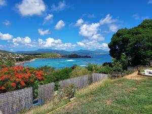 a view of the ocean from a fence at la villa caribéenne de la plage des surfeurs in La Trinité