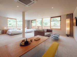 uma sala de estar com um sofá e uma mesa em Hatago Vison 