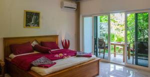 a bedroom with a bed with red pillows at Senggigi Homes & Apartments in Senggigi 