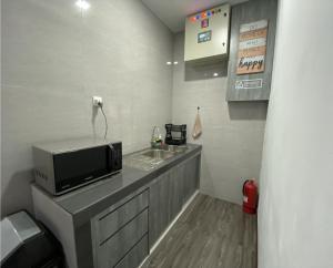 a small kitchen with a microwave and a sink at CN Homestay A1 Floor 1 at Nagoya Hill Mall in Jodoh