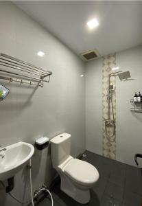 La salle de bains est pourvue de toilettes blanches et d'un lavabo. dans l'établissement CN Homestay A1 Floor 1 at Nagoya Hill Mall, à Jodoh