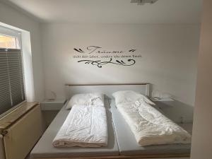 a bedroom with two beds and a sign on the wall at Bungalow im Garten in Wiek in Wiek auf Rügen