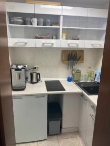 a kitchen with white cabinets and a counter top at Bungalow im Garten in Wiek in Wiek auf Rügen