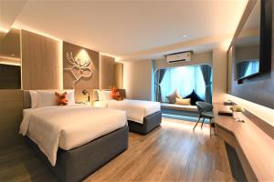 清邁的住宿－Moose Hotel Nimman，酒店客房设有两张床和窗户。