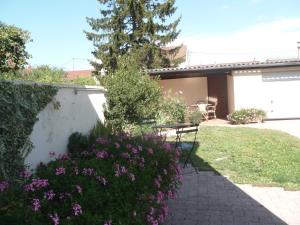 un jardin avec un banc et des fleurs violettes dans l'établissement L'Escale Dijonnaise, à Dijon