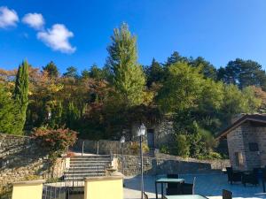 un patio con escaleras, una pared de piedra y árboles en Borgo I Tre Baroni - Spa Suites & Resort en Poppi