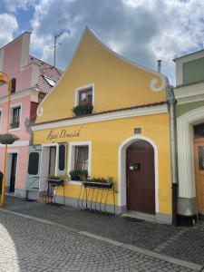 un bâtiment jaune sur le côté d'une rue dans l'établissement Apartmány Žlutý domeček, à Třeboň