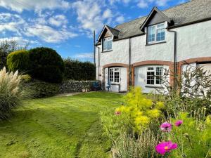 a house with a yard with flowers in front of it at Honeysuckle Cottage in Ilfracombe