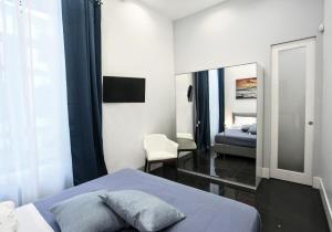 - une chambre avec un lit et un miroir dans l'établissement DUOMO LUXORY HOME, à Naples