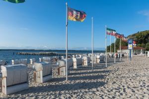 a beach with a bunch of chairs and a flag at Ferienwohnung Pape in Glücksburg
