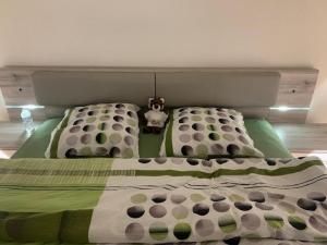 1 cama con edredón y almohadas verdes y blancos en Superbe appartement dans la marina du Bouveret, en Port-Valais