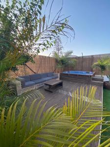 un patio con un sofá azul, mesas y plantas en Villa Tijuana - Jacuzzi, Playa y Naturaleza en Gran Canaria, en Las Palmas de Gran Canaria