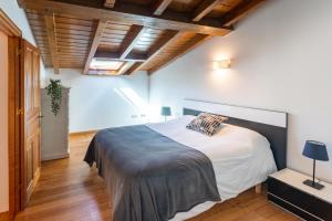 1 dormitorio con cama grande y techo de madera en Casa Rural La Escallada, en Turanzas