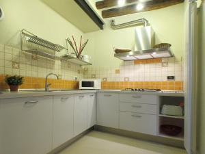 a white kitchen with a sink and a microwave at Ca Guardiani in Venice