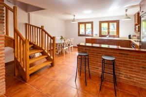 a kitchen and dining room with a brick counter and stools at Casa Rural La Escallada in Turanzas