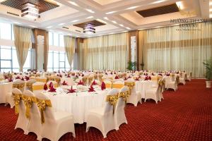 um grande salão de banquetes com mesas e cadeiras brancas em Muong Thanh Luxury Nha Trang Hotel em Nha Trang