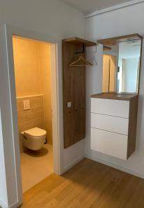 La salle de bains est pourvue de toilettes, d'un lavabo et d'un miroir. dans l'établissement Apartman ARIA, à Zagreb