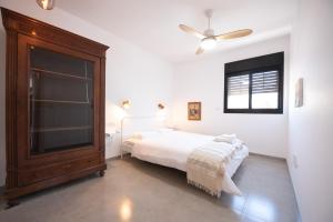 1 dormitorio con 1 cama y ventilador de techo en PORT CITY HAIFA - Bat Galim 20m from the beach en Haifa