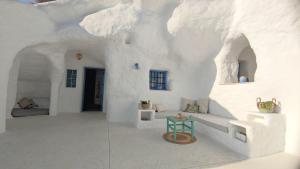 a living room with white walls and a table at Complejo Cuevas Otto in Baza