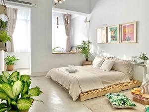 um quarto com uma cama num quarto com plantas em 闆娘公寓 em Kaohsiung