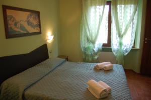 ein Schlafzimmer mit einem Bett mit zwei Handtüchern darauf in der Unterkunft Mariani Bed&Breakfast in Castellina in Chianti