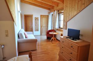 a living room with a television on a dresser at Hansbauerhof in Rattendorf