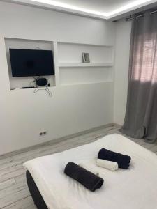 ein Schlafzimmer mit einem Bett mit zwei schwarzen Kissen darauf in der Unterkunft Residence D'Azur Apartments near Palais des Festivals in Cannes