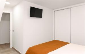 - une chambre avec des murs blancs et une télévision murale dans l'établissement 2 Bedroom Lovely Home In Isla Cristina, à Isla Cristina
