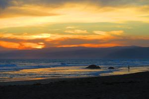 eine Person, die bei Sonnenuntergang am Strand steht in der Unterkunft Kates Cottage in Aireys Inlet + 1 Foto