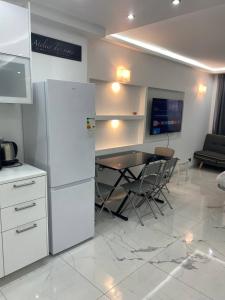 eine Küche mit einem Tisch und einem weißen Kühlschrank in der Unterkunft Residence D'Azur Apartments near Palais des Festivals in Cannes