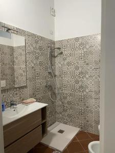 a bathroom with a shower and a sink and a mirror at Appartamento Minerva in Palo del Colle