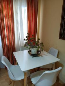 einem weißen Tisch mit Stühlen und einer Topfpflanze darauf in der Unterkunft Apartamento la Concha in Chiclana de la Frontera