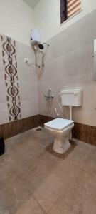 a bathroom with a white toilet in a room at Sneha Farm House in Kudal