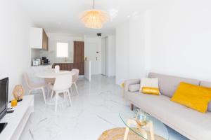 een witte woonkamer met een bank en een tafel bij LE RIVIERA - MONACO - 2 PIECES - Terrasse in Beausoleil